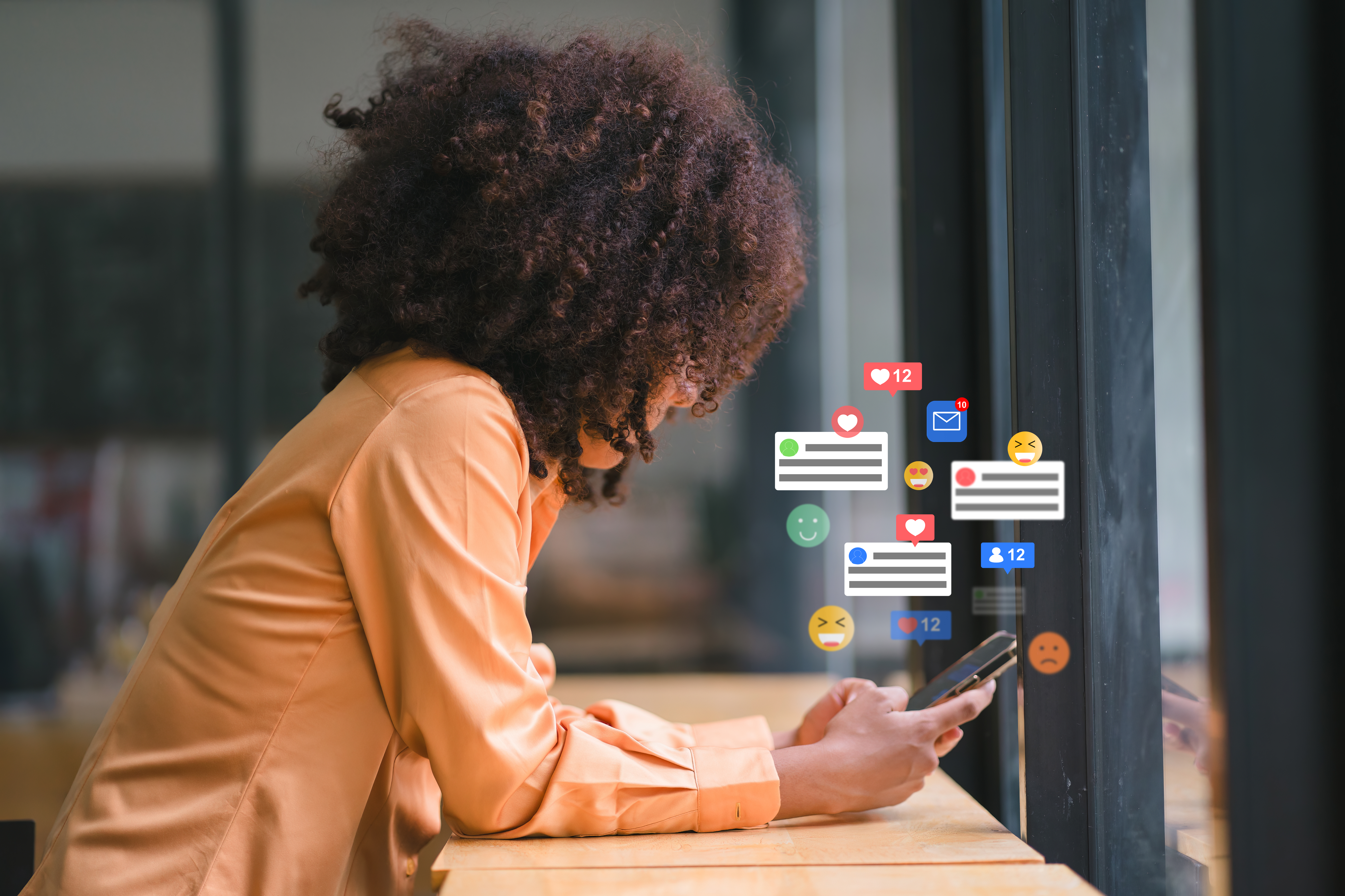 Smiling african american businesswoman engaging with social media on smartphone at modern workspace