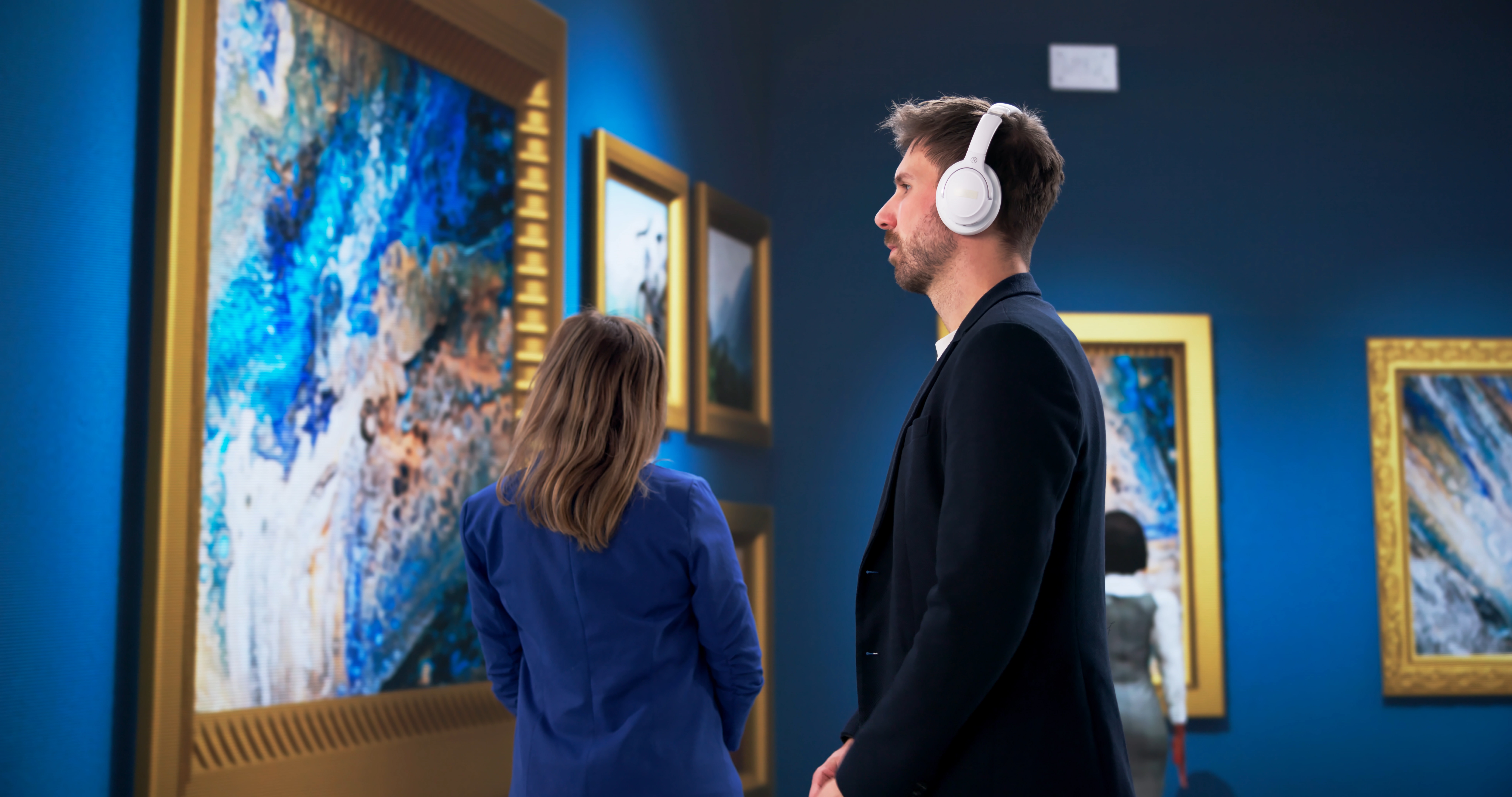 Young Couple Enjoying Audio Guide While Touring Museum Exhibits